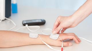Elektrotherapie an der Hand